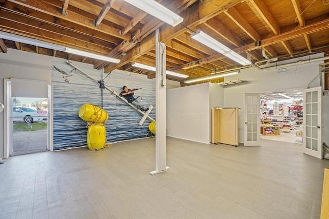 below grade area with french doors and wood finished floors