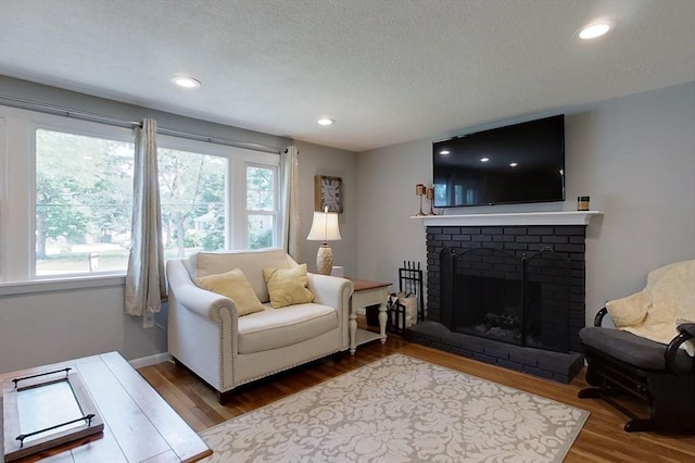 12 Pine St, Pepperell, MA 01463 - living room with wood finished floors, a fireplace, a textured ceiling, and recessed lighting