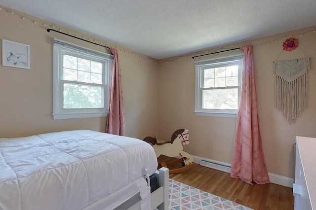 12 Pine St, Pepperell, MA 01463 - bedroom with multiple windows, baseboard heating, and light wood-type flooring