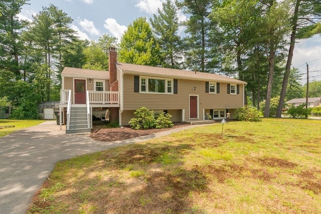 12 Pine St, Pepperell, MA 01463 - bi-level home featuring driveway, a chimney, a deck, a front lawn, and stairs
