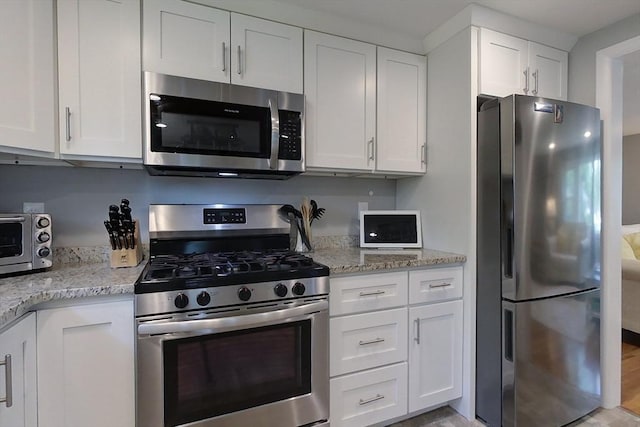 12 Pine St, Pepperell, MA 01463 - kitchen with appliances with stainless steel finishes, white cabinets, and light stone countertops