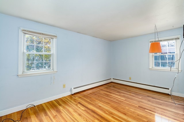 unfurnished room featuring light hardwood / wood-style floors, a wealth of natural light, and a baseboard radiator