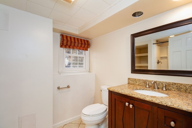 bathroom with tile patterned flooring, vanity, toilet, and walk in shower