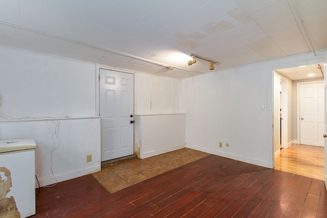 basement featuring dark hardwood / wood-style flooring and fridge