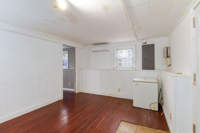 interior space with a wall mounted air conditioner, electric panel, and dark hardwood / wood-style floors