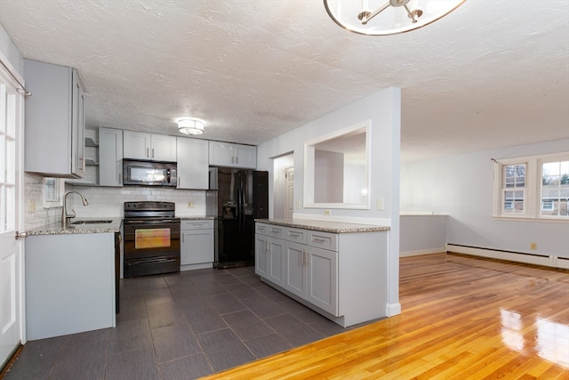 kitchen with gray cabinets, decorative backsplash, sink, and black appliances