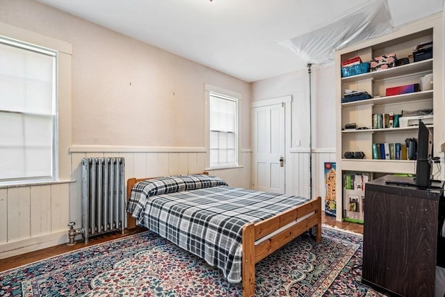 400 N Woodstock Rd, Southbridge, MA 01550 - bedroom with wood finished floors, radiator heating unit, wooden walls, and a wainscoted wall