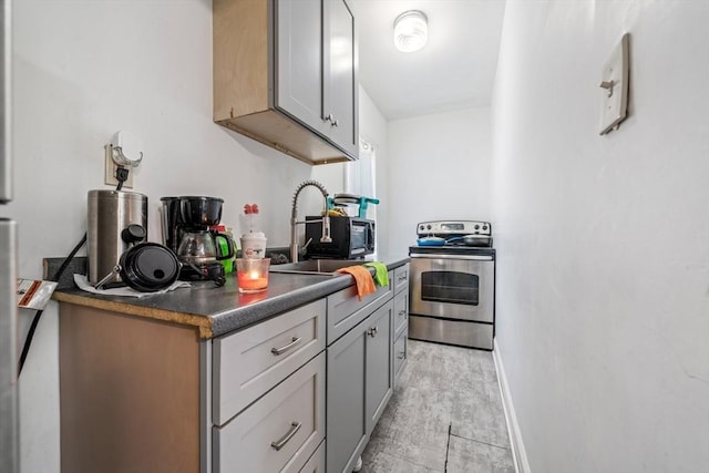 400 N Woodstock Rd, Southbridge, MA 01550 - kitchen featuring a sink, dark countertops, stainless steel electric range, gray cabinetry, and baseboards