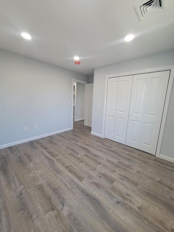 unfurnished bedroom with a closet and light wood-type flooring