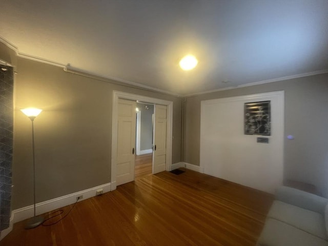 empty room with hardwood / wood-style floors and ornamental molding