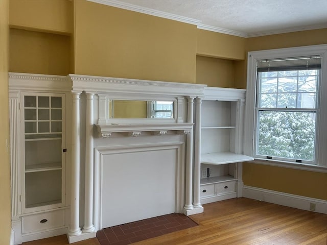 interior details featuring built in shelves, ornamental molding, a textured ceiling, and hardwood / wood-style flooring