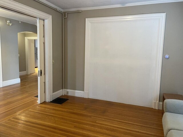 interior space with wood-type flooring and ornamental molding