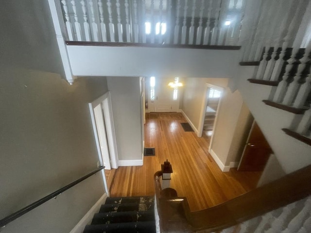 stairway featuring a towering ceiling and hardwood / wood-style flooring