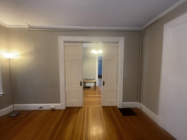 unfurnished room featuring wood-type flooring and ornamental molding