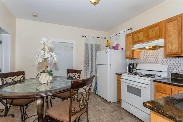 56-A Topliff St, Boston, MA 02122 - kitchen featuring white appliances, under cabinet range hood, decorative backsplash, brown cabinetry, and dark stone counters