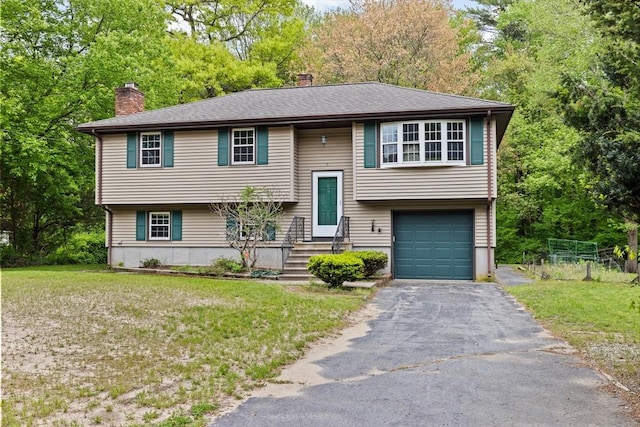 5 Glad St, Freetown, MA 02702 - raised ranch with a chimney, a garage, asphalt driveway, a front lawn, and view of wooded area