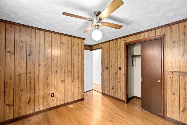 5 Glad St, Freetown, MA 02702 - unfurnished bedroom with light wood-type flooring, wood walls, a closet, baseboards, and a ceiling fan