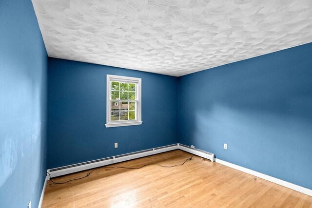 5 Glad St, Freetown, MA 02702 - empty room with a textured ceiling, wood finished floors, baseboards, and a baseboard radiator