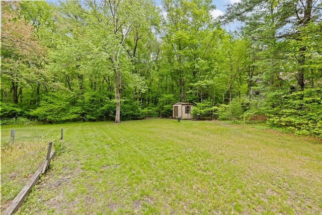 5 Glad St, Freetown, MA 02702 - view of green lawn featuring a storage unit, an outbuilding, and a wooded view