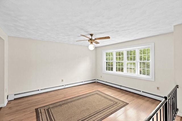 5 Glad St, Freetown, MA 02702 - empty room with wood finished floors, a ceiling fan, a baseboard heating unit, baseboards, and a textured ceiling