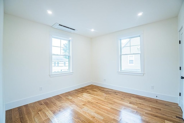 spare room featuring recessed lighting, baseboards, visible vents, and wood finished floors
