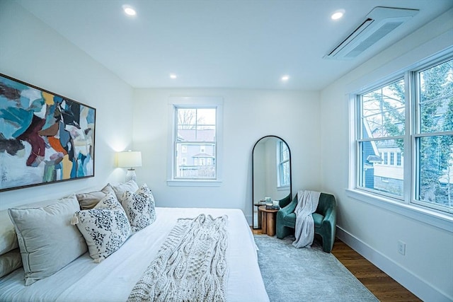 bedroom featuring recessed lighting, wood finished floors, and multiple windows