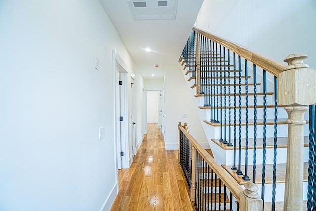 hallway with baseboards, recessed lighting, wood finished floors, and stairway