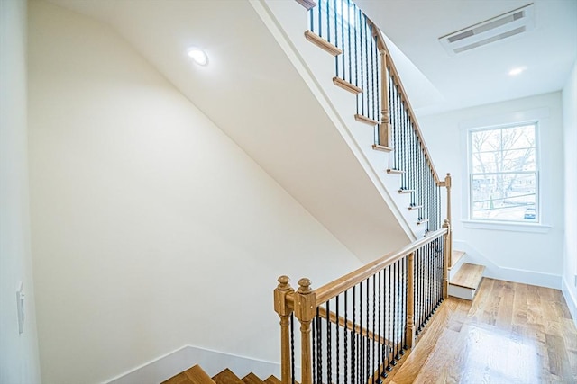 stairway with visible vents, recessed lighting, baseboards, and wood finished floors