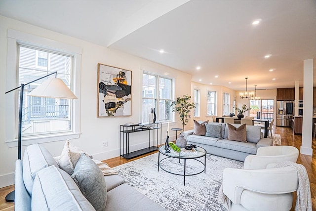 living area featuring recessed lighting, baseboards, wood finished floors, and a chandelier