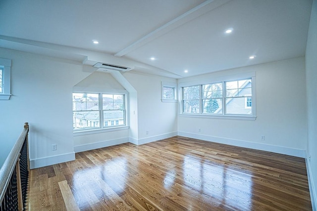 interior space featuring wood finished floors, baseboards, recessed lighting, vaulted ceiling with beams, and a wall mounted AC