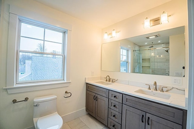 bathroom with toilet, baseboards, a shower stall, and a sink