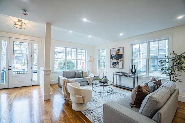 living room with baseboards, wood finished floors, a wealth of natural light, and vaulted ceiling