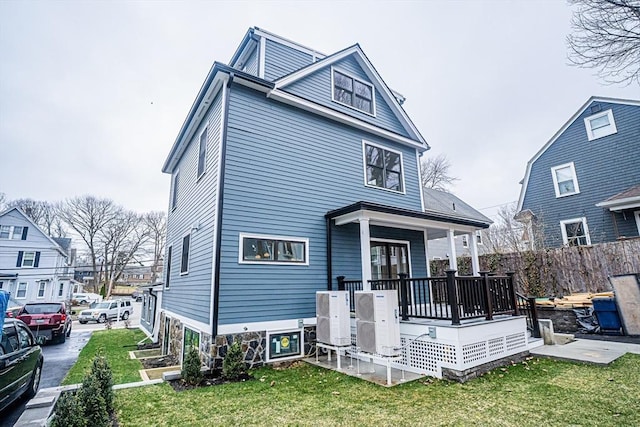 view of front of home with fence, ac unit, a porch, and a front lawn