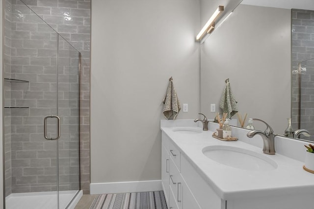 bathroom featuring double vanity, a shower stall, and a sink
