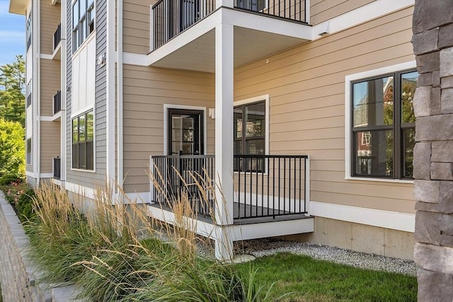 view of exterior entry with a porch and a balcony