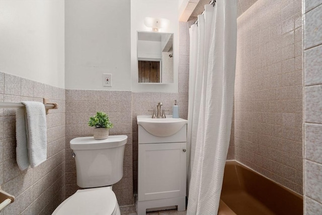 bathroom with vanity, toilet, tile walls, a wainscoted wall, and a shower with curtain