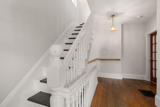 staircase with baseboards, hardwood / wood-style flooring, and visible vents