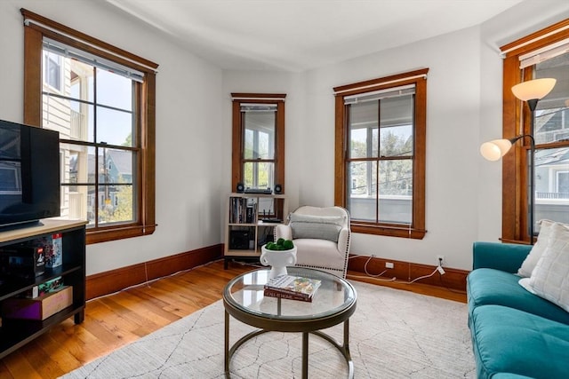 living area with baseboards and wood finished floors