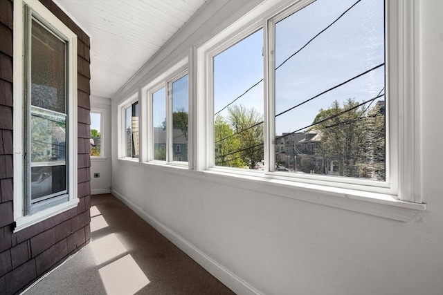 unfurnished sunroom featuring baseboards