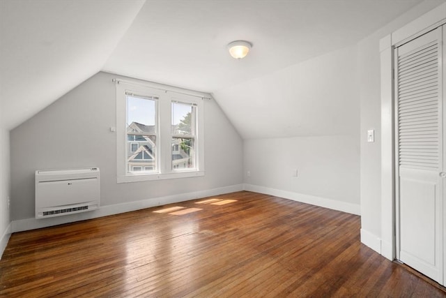 bonus room featuring heating unit, baseboards, vaulted ceiling, and hardwood / wood-style flooring