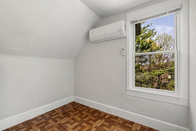 additional living space featuring baseboards, a wall mounted AC, and lofted ceiling