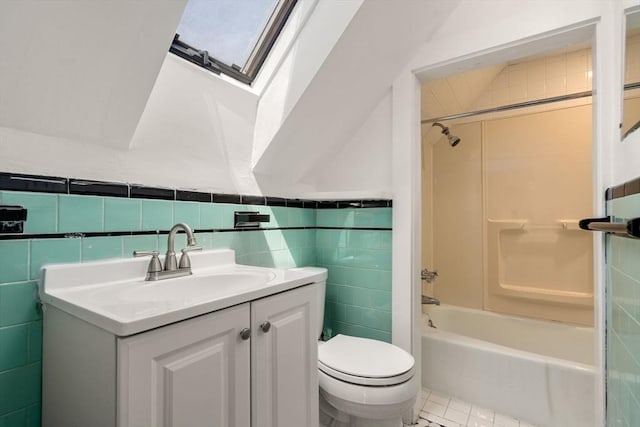 full bath with vanity, washtub / shower combination, toilet, and tile walls