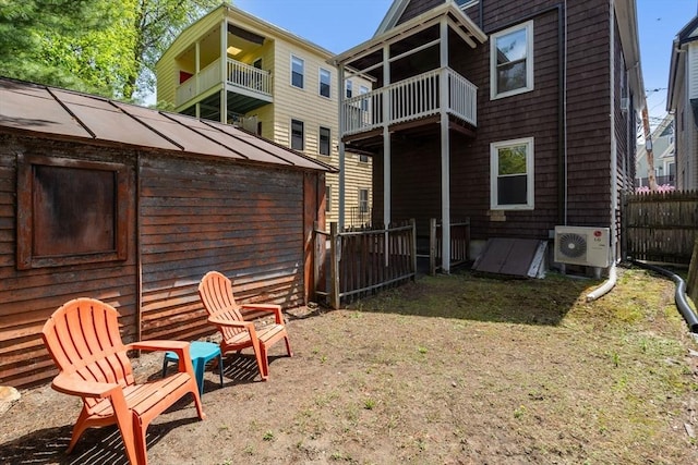exterior space featuring fence, ac unit, and a balcony