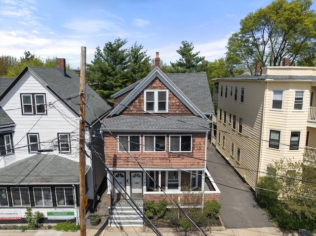 view of front of property featuring a shingled roof and covered porch