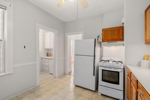kitchen featuring white appliances, light floors, ceiling fan, under cabinet range hood, and brown cabinets