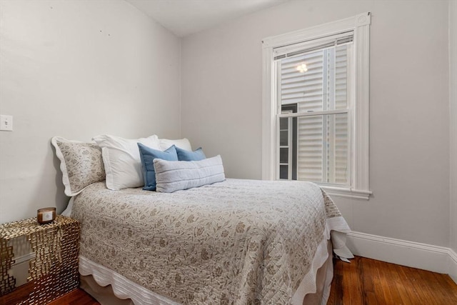 bedroom with baseboards and wood finished floors