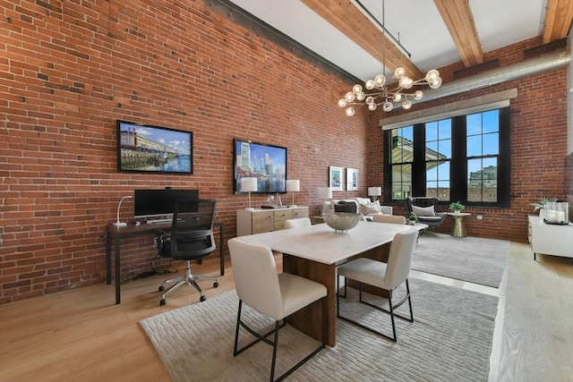 dining room with an inviting chandelier, brick wall, wood finished floors, beam ceiling, and a high ceiling