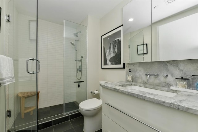 bathroom with vanity, toilet, tile patterned flooring, and a shower stall