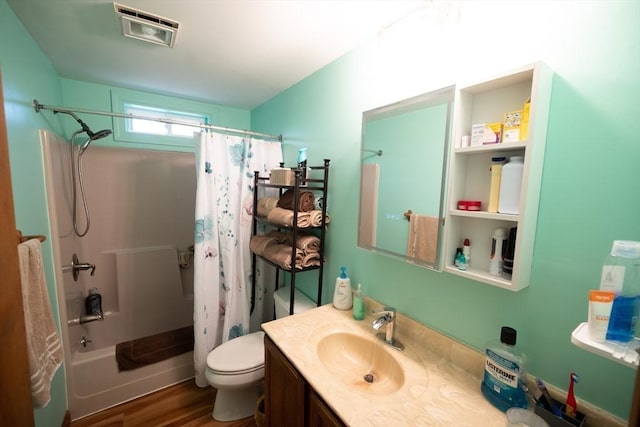 bathroom with visible vents, vanity, wood finished floors, shower / bath combination with curtain, and toilet