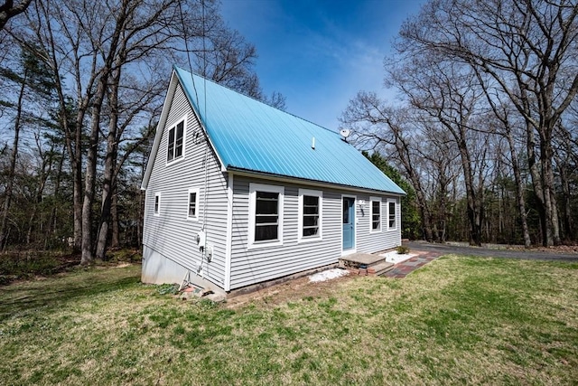 exterior space with metal roof and a front lawn